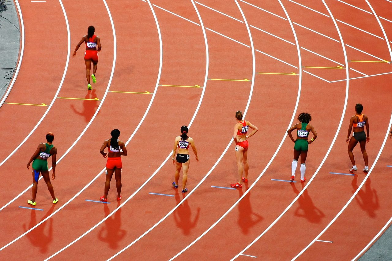 Des sprinteuses lancées dans le virage d'une piste d'athlétisme