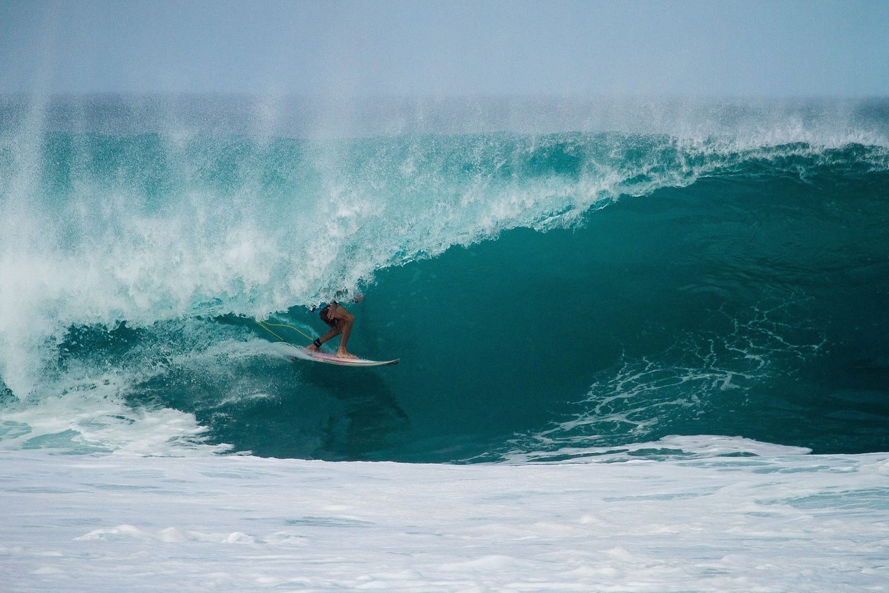 Un surfeur trace sa courbe dans le creux d'une vague